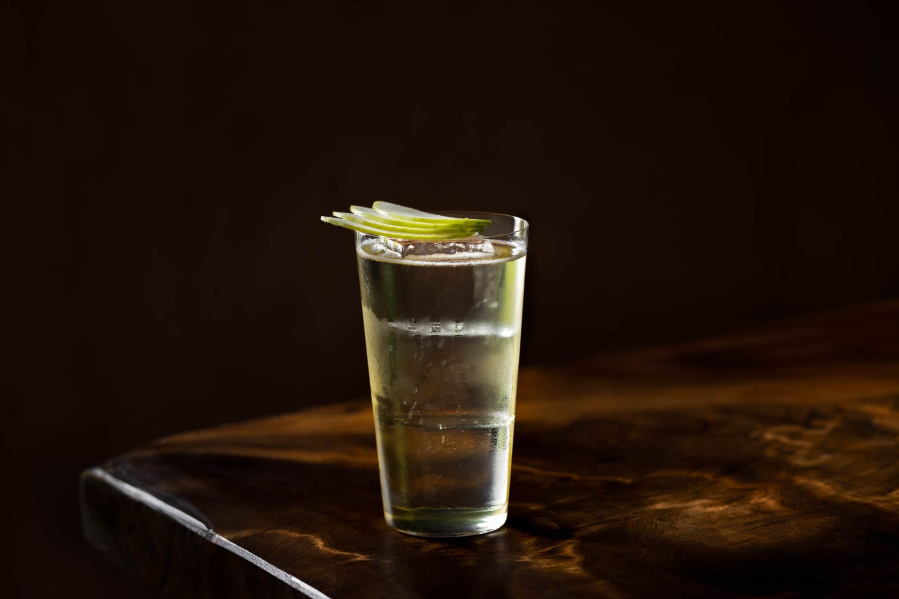 Tall highball with sliced green apple